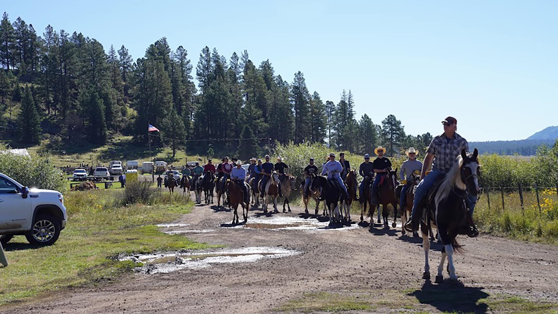 Line of Tempe Diablos riders on horseback heading out from camp on the Trail Ride